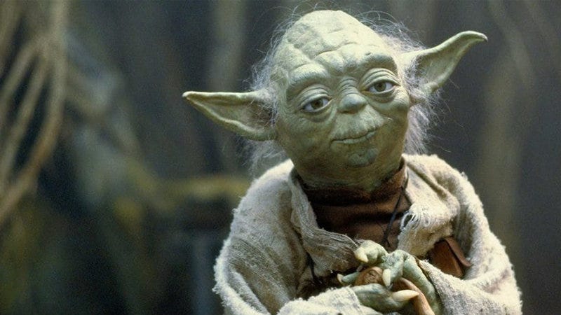 Yoda, personaggio di Star Wars. Ha la pelle verde e rugosa, orecchie lunghe e appuntite, e un'espressione serena. Indossa una veste semplice, con uno sfondo sfocato che richiama una foresta o un ambiente naturale. Yoda, personaggio di Star Wars. Ha la pelle verde e rugosa, orecchie lunghe e appuntite, e un'espressione serena. Indossa una veste semplice, con uno sfondo sfocato che richiama una foresta o un ambiente naturale.