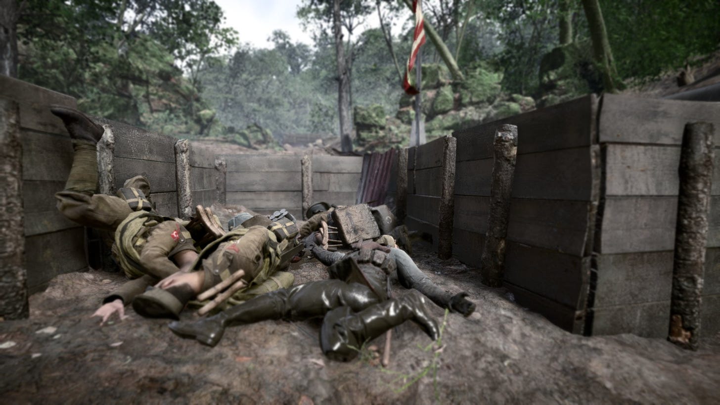 Dead soldiers lied sprawled in a pile in a trench under an American flag.