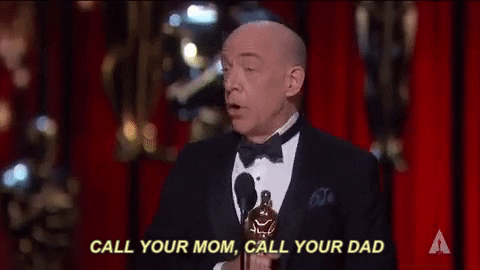 GIF: JK Simmons, accepting an award, says, "Call your mom, call your dad"
