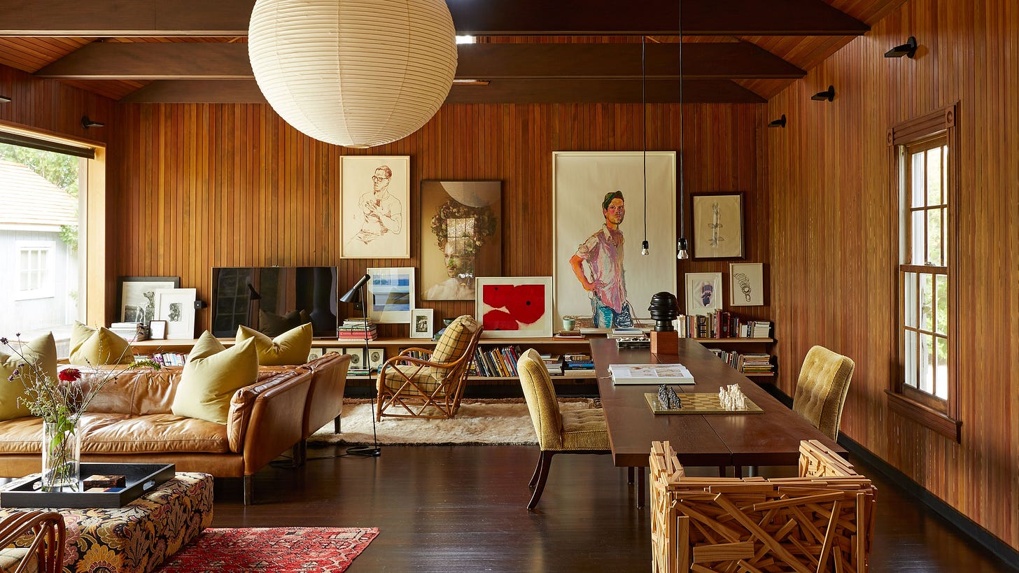 a living room filled with eclectic pieces of furniture and artwork along one wall