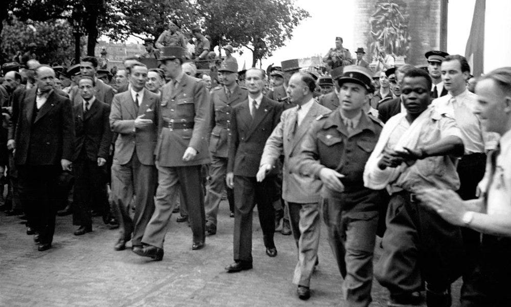 Black and white photo taken of a crowded street scene in Paris with General de Gaulle in the centre, with a single black man, George Dukson, in the foreground to the right being  manhandled and pushed out of the way.