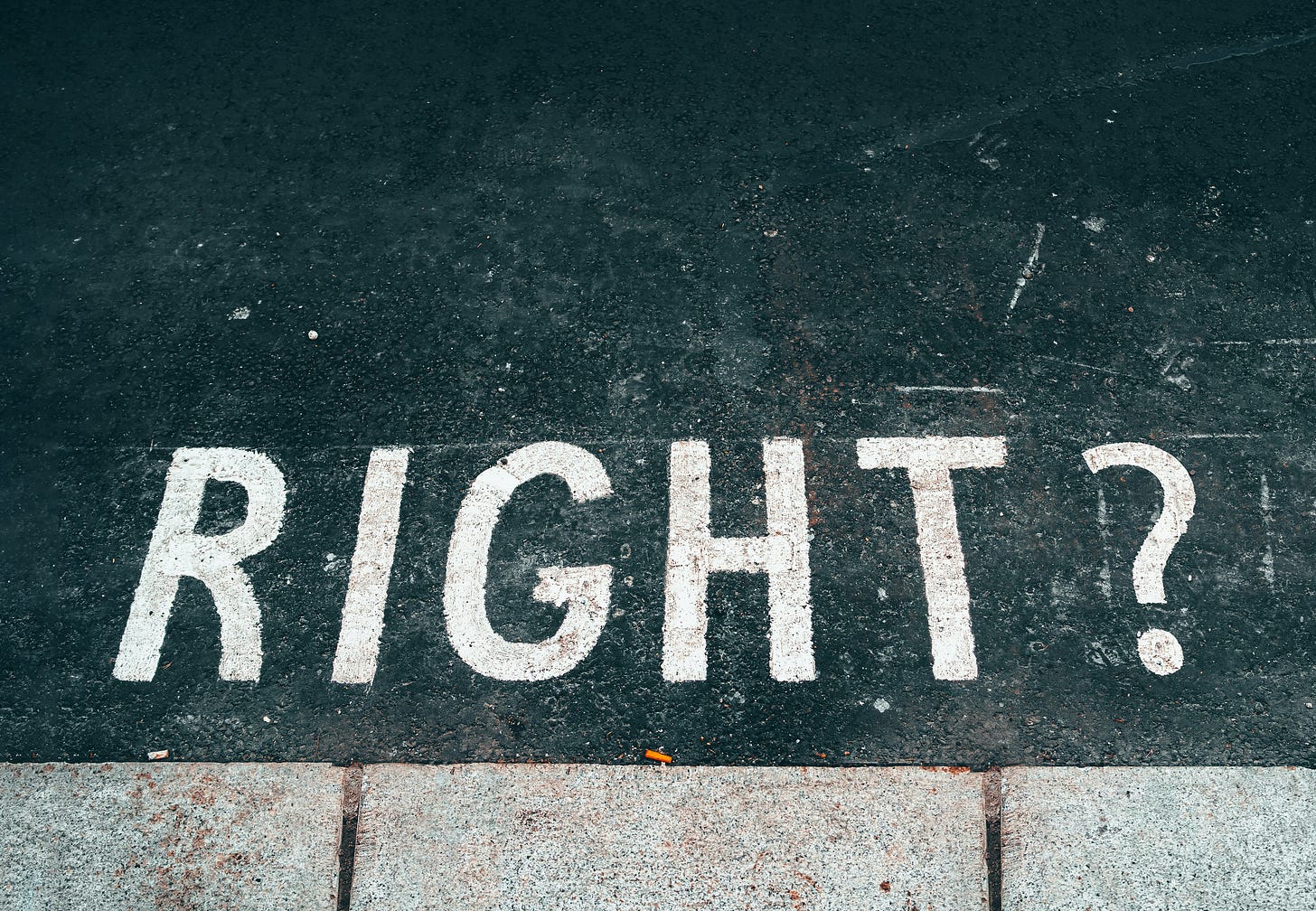 An image of the word "Right?" painted in capital letters on a street.