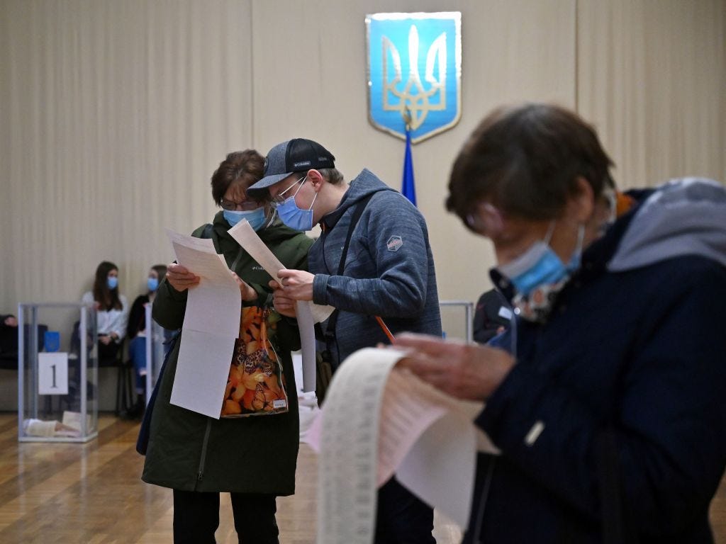 Voters examine their ballots at at Kyiv polling station in 2020.