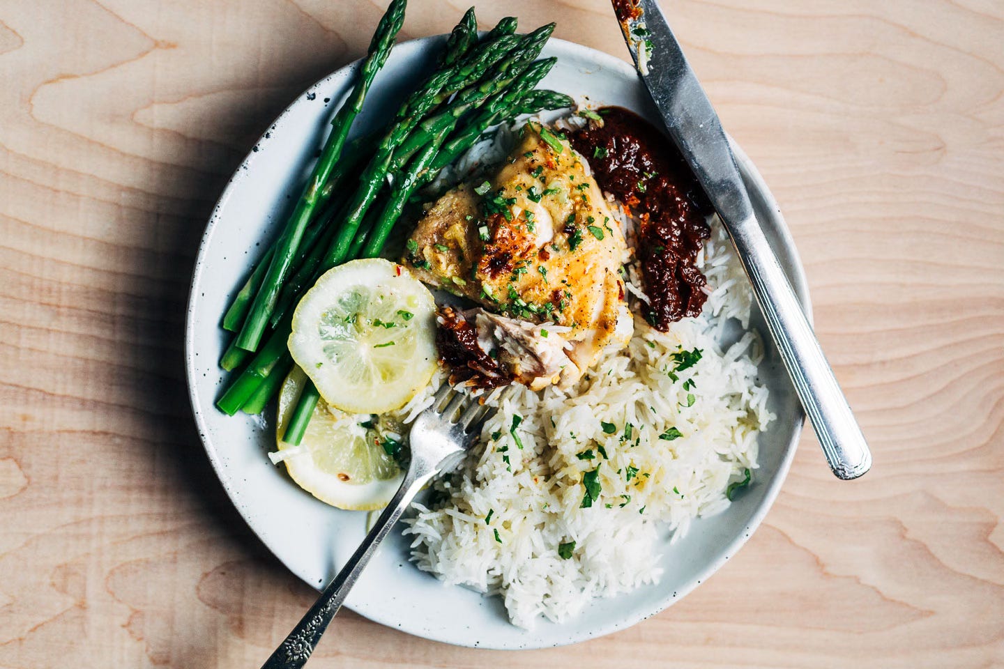 A plate with chicken, rice, and asparagus.