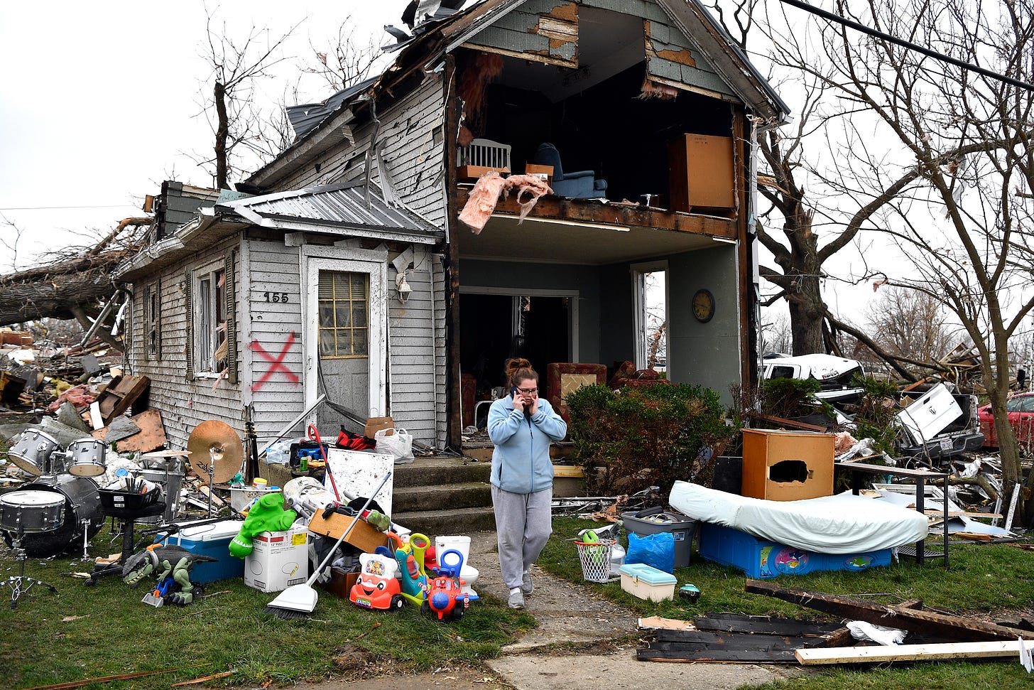 Brittany Oakley checks in with relatives outside of what is left of her home in Lakeview, Ohio on Friday.