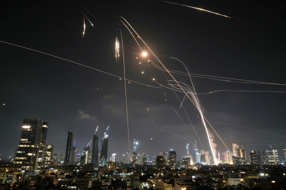 Iron Dome air defense system intercepting missiles over Tel Aviv at night.