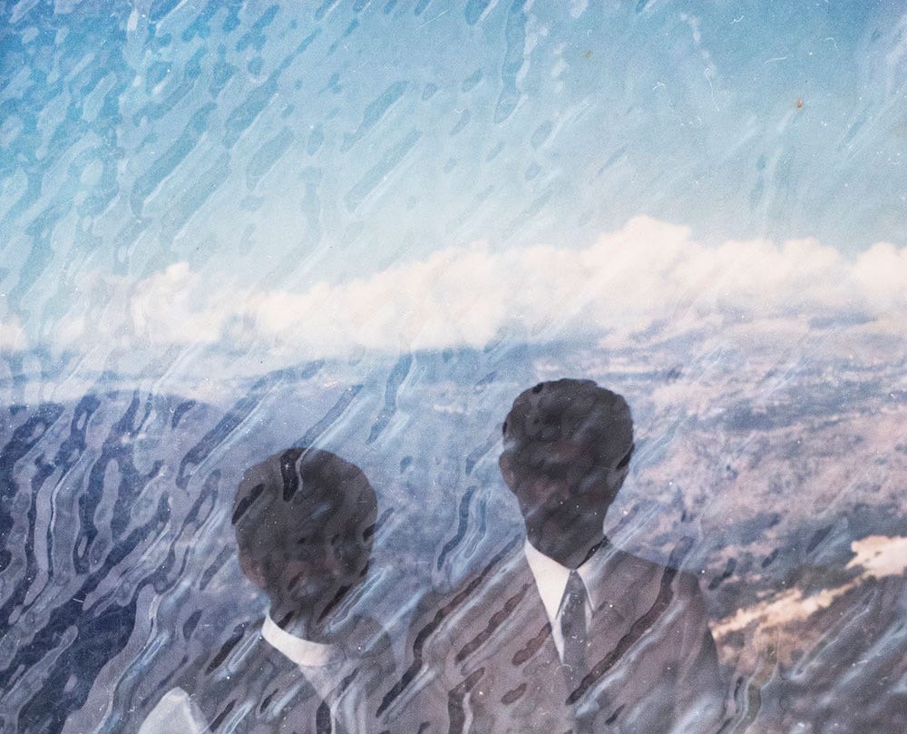A damaged photograph of a landscape showing scrub brush, hills and uncultivated fields. Two people in western dress associated with men (a suit and tie) and women (A dress) have been painted on top of the landscape. Their faces are blanked out.