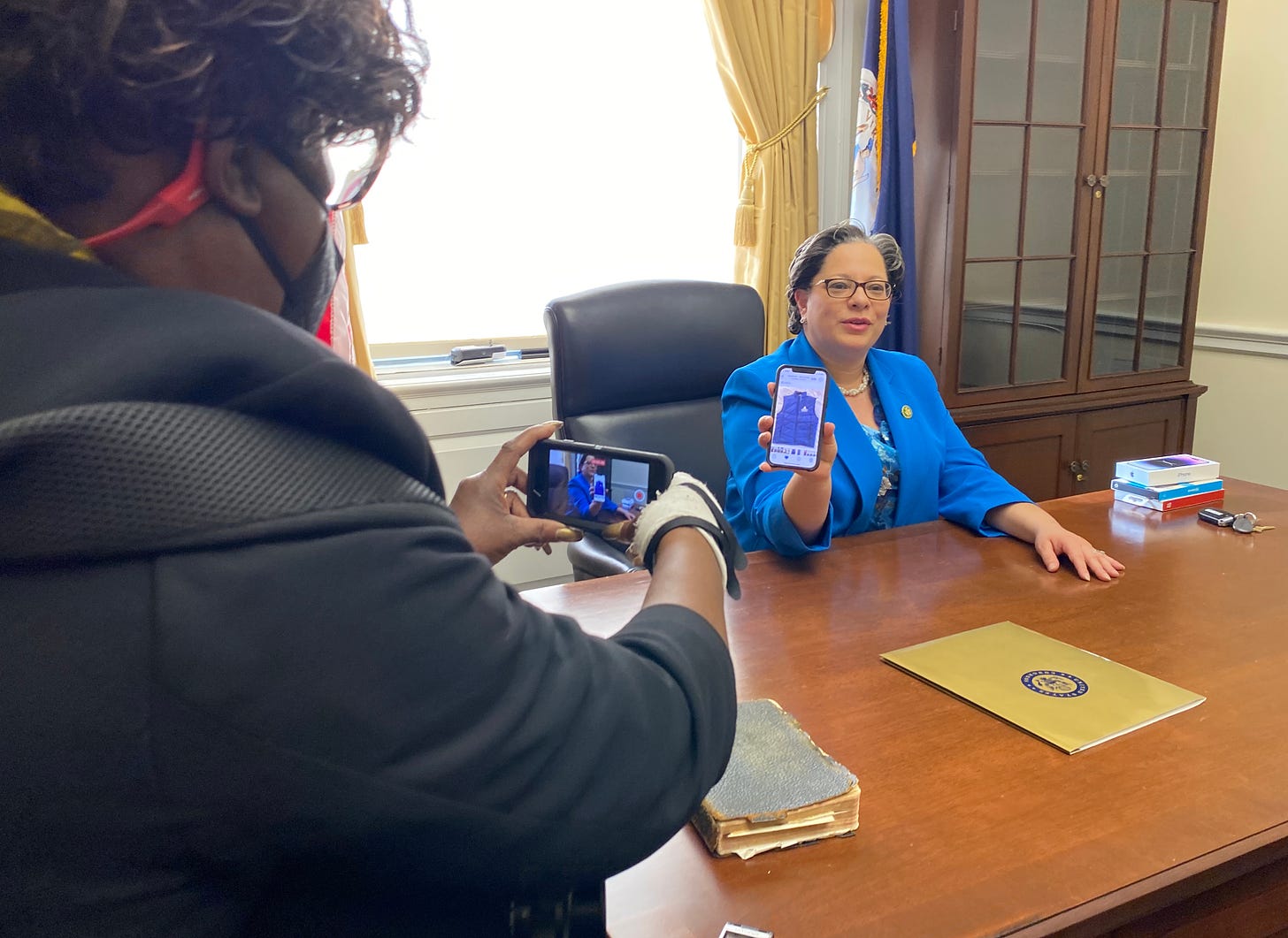 Rep. Jennifer McClellan shows reporters a vest given to her by her CBC colleagues