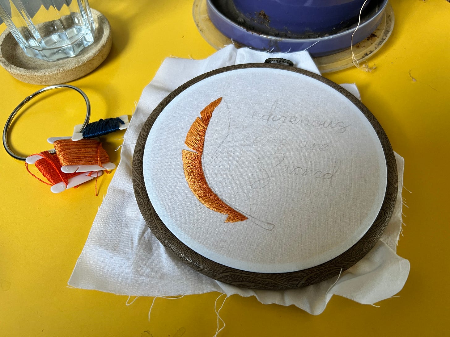 Photo of the in-progress orange feather design I am doing to accompany the phrase ‘Indigenous Lives are Sacred’. 