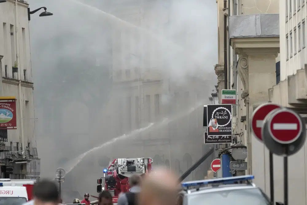 Firemen use a water canon as they fight a blaze Wednesday, June 21, 2023 in Paris. Firefighters fought a blaze on Paris' Left Bank that is sent smoke soaring over the domed Pantheon monument and prompted evacuation of buildings in the neighborhood, police said. Local media cited witnesses describing a large explosion preceding the fire, and saying that part of a building collapsed. (AP Photo/Christophe Ena)