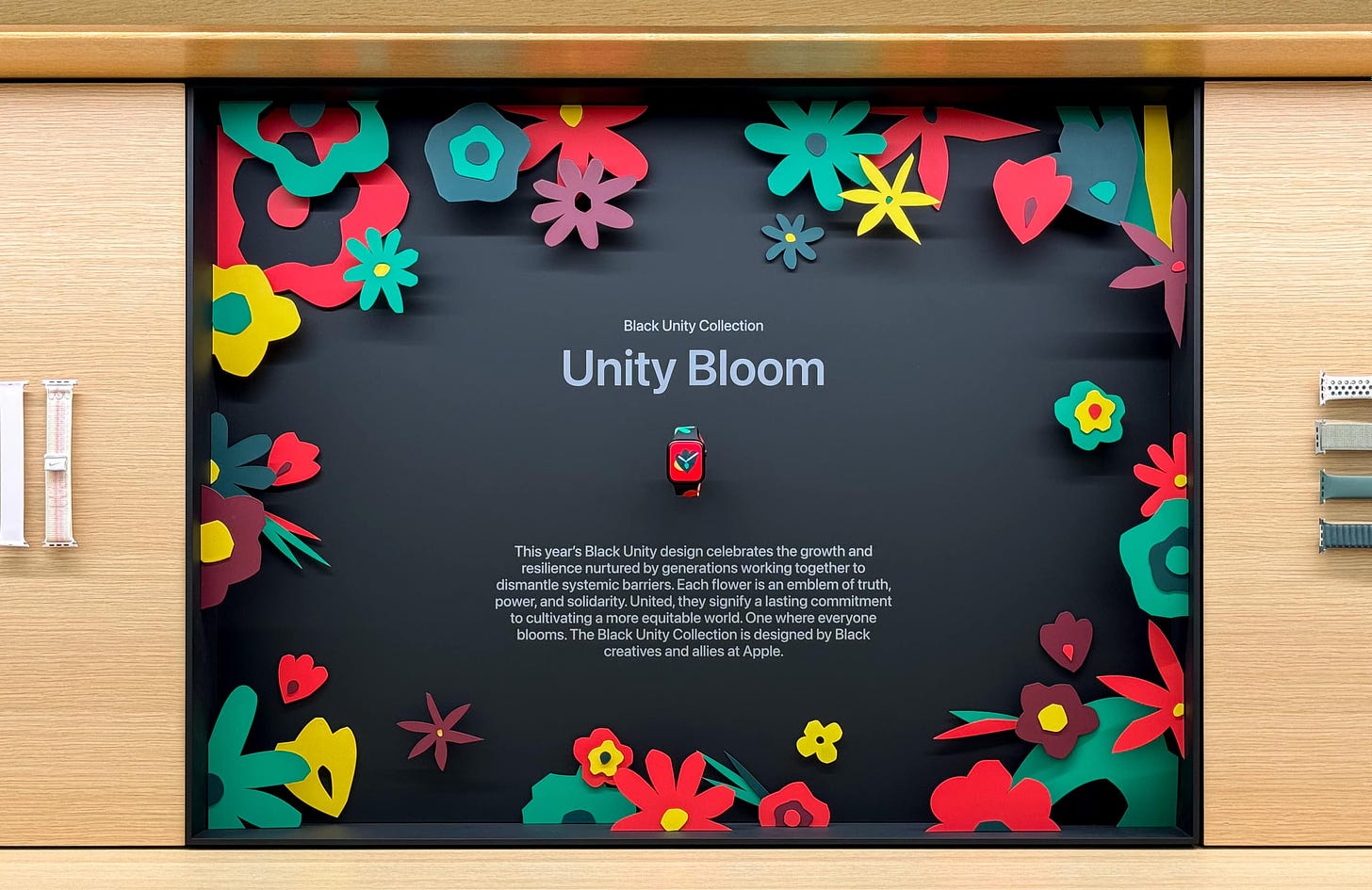 The Apple Watch Unity Bloom bay. Floral patterns are set against a black background.