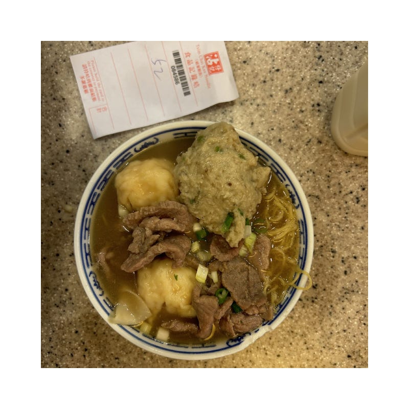 photo of my lunch in Hong Kong: sliced beef, fish ball, and wontons over yellow noodle soup