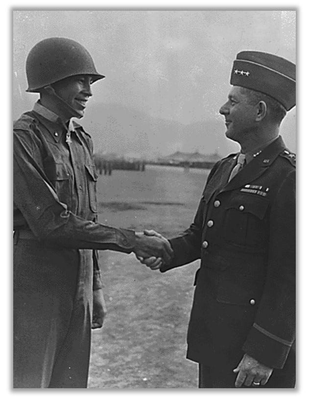 Ernest Childers receives the Medal of Honor from Lieutenant General Jacob Devers.  The two men are smiling and standing on a field in Italy.