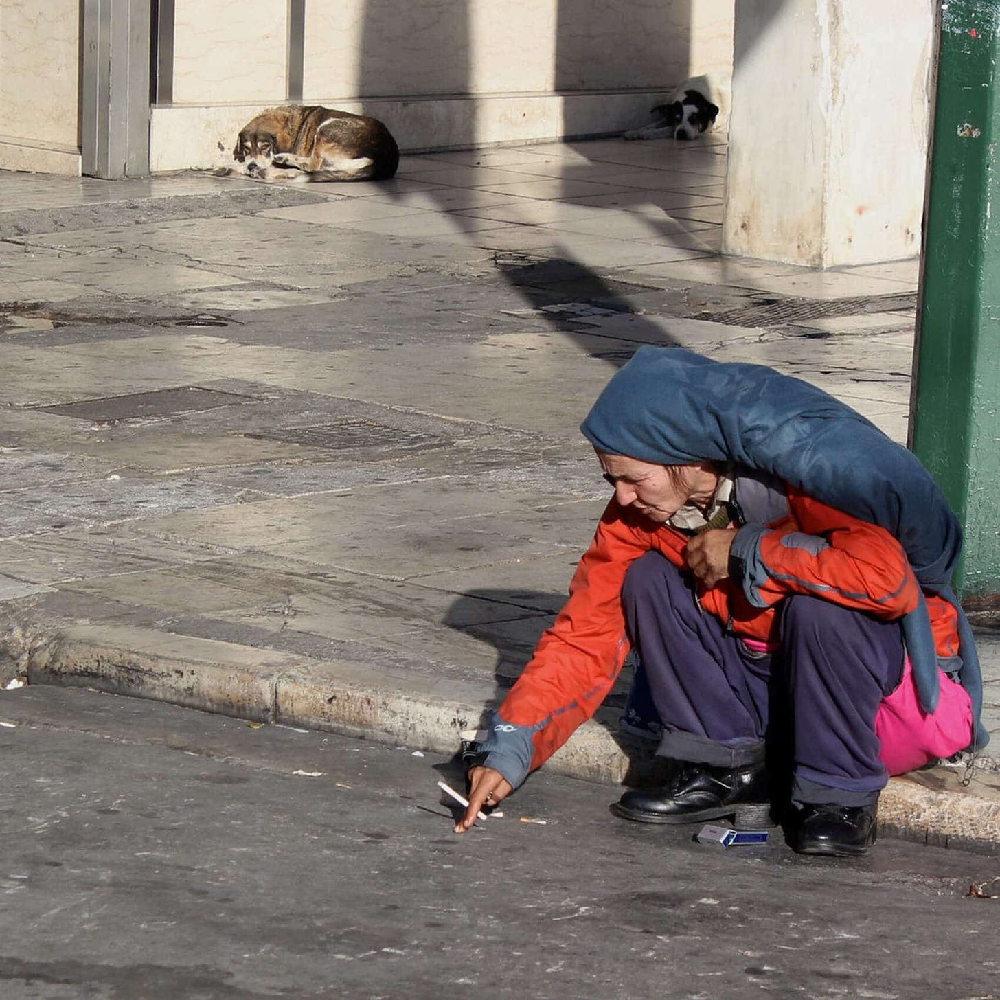 Homeless woman near Syntagma Square on a crisp autumn morning in Athens, reflecting economic hardship in Greece