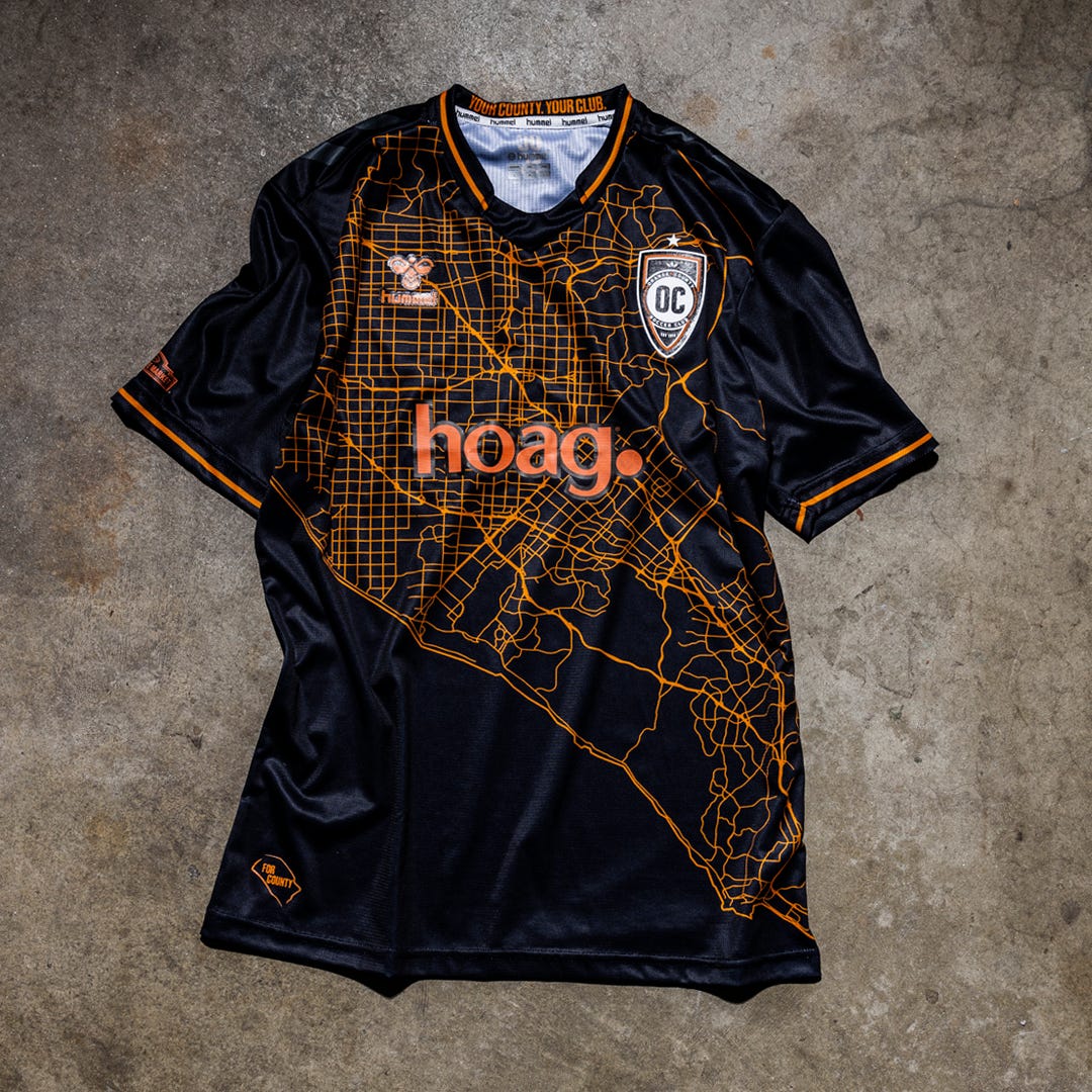 Photo of Orange County SC's new away jersey for 2024, featuring a street grid in orange against a black background.