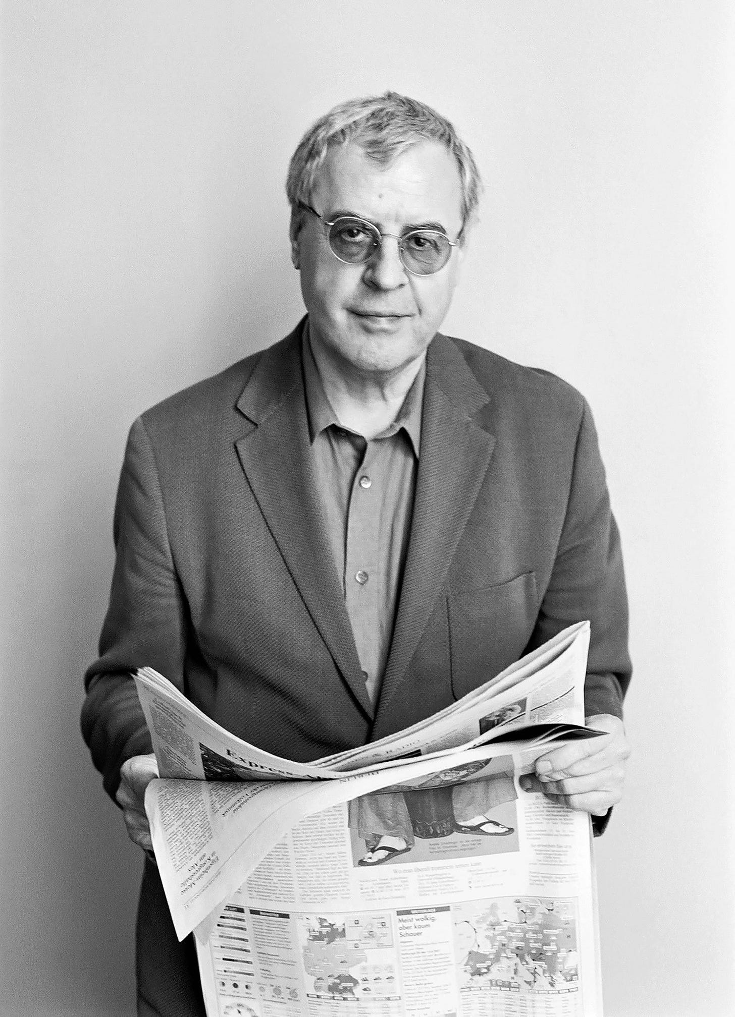 black and white photo of a man with dark glasses holding a newspaper
