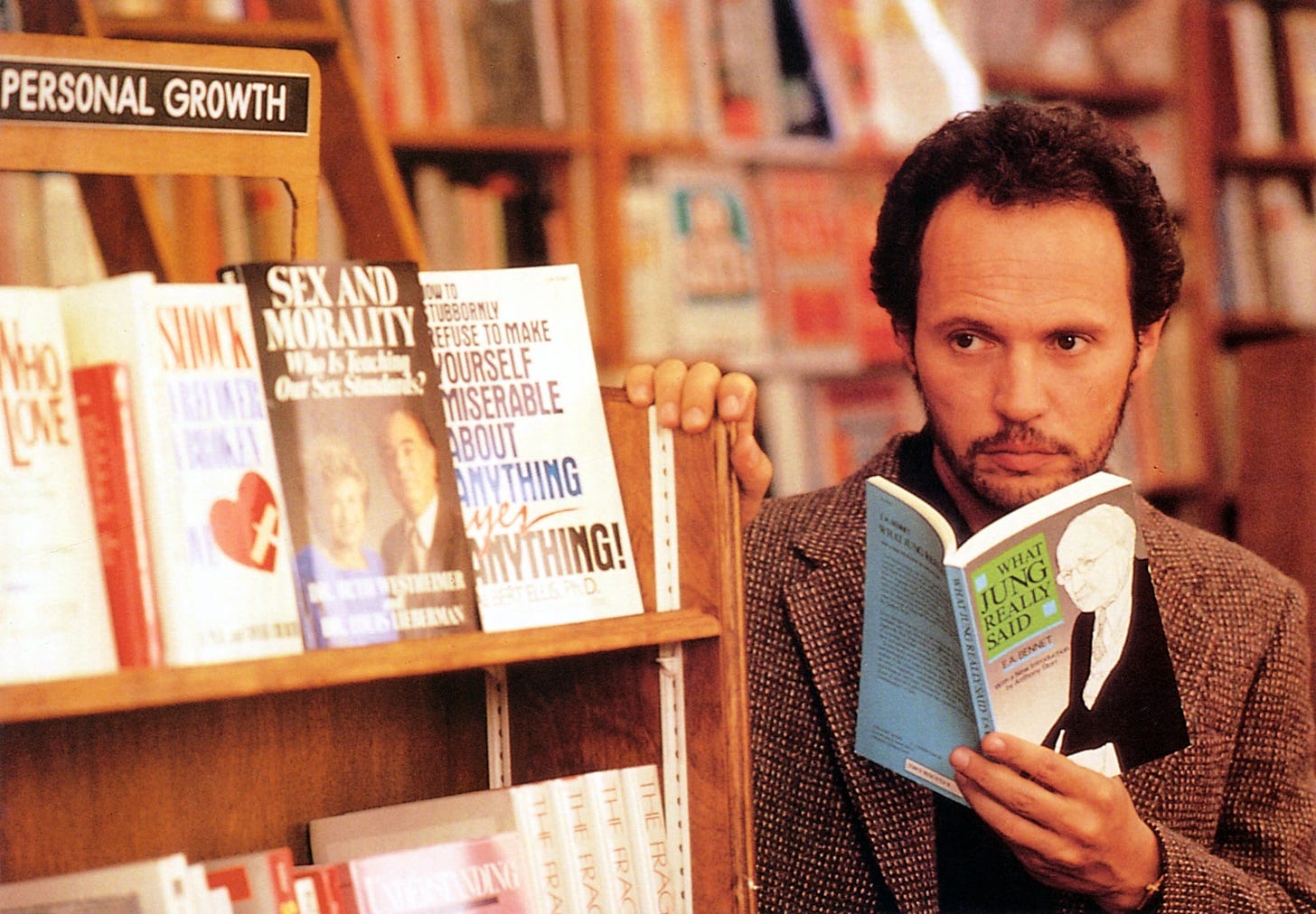 Harry in a book store, pretending to read but staring somewhere else