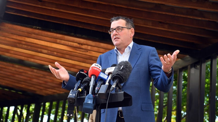 Victorian Premier Daniel Andrews speaks to media during a press conference with his hands outstretched.
