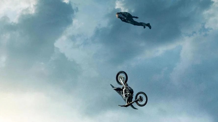 Tom Cruise doing his jump a motorbike off a mountain stunt from the new Mission: Impossible movie.