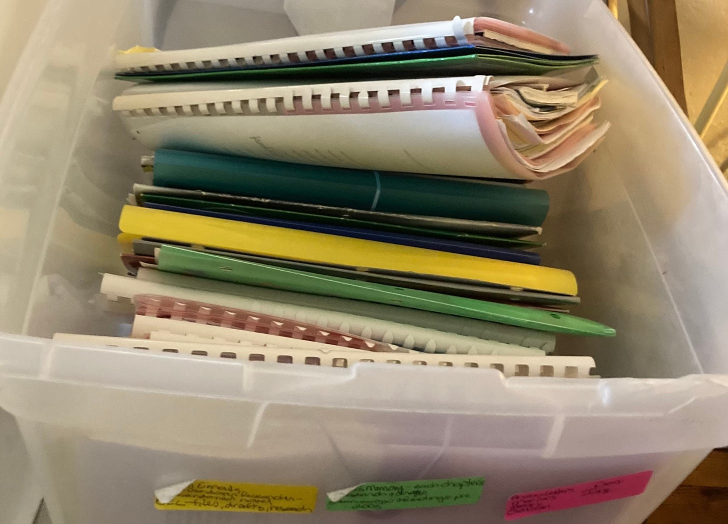A plastic bin full of bulging file folders.
