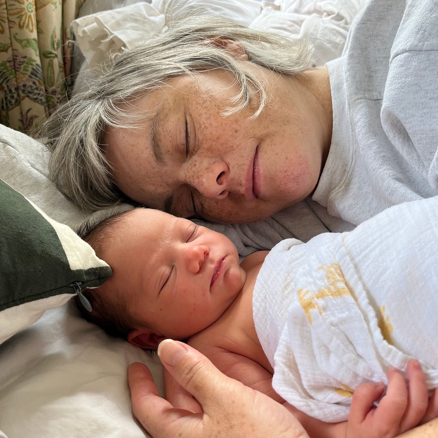 A photograph of a woman with a newborn infant, both sleeping.