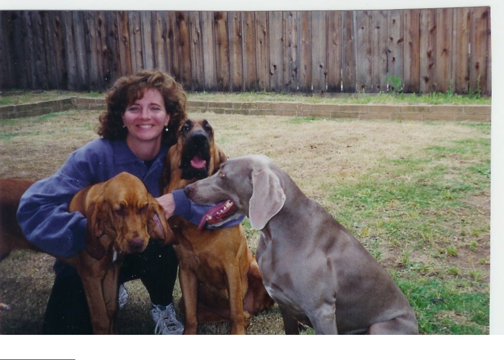 Author kneeling with her three dogs: Chase, A.J., and Rachel