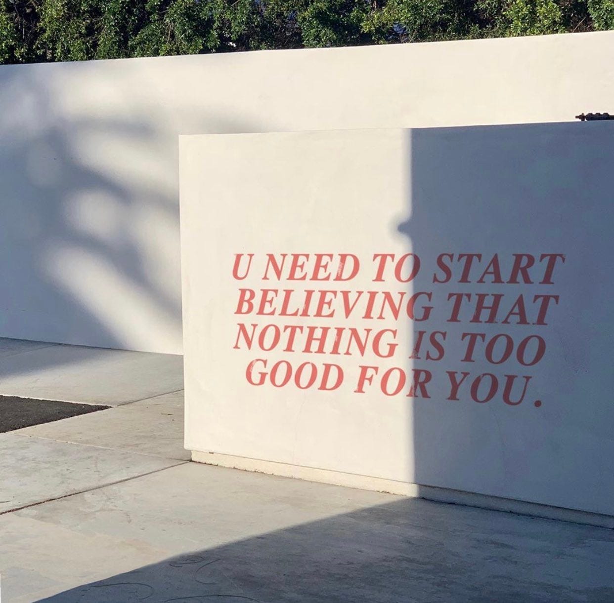 White wall with "You need to start believing that nothing is too good for you." in pink lettering