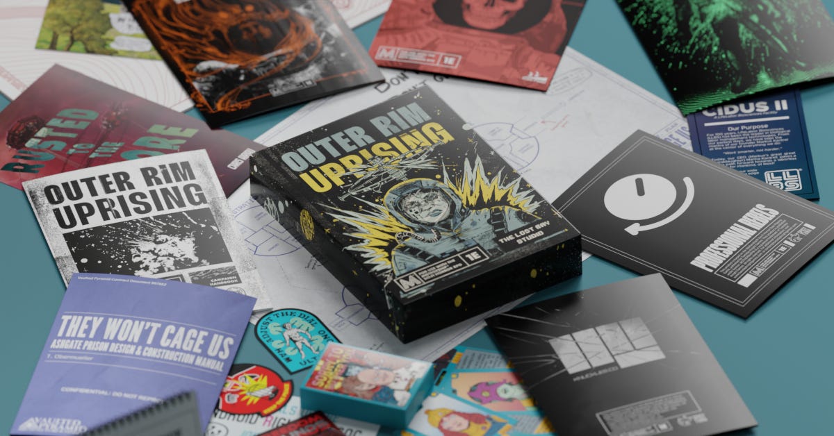 A box reading “Outer Rim: Uprising” sits atop a mass of zines, pamphlets, cards, patches, and even a cassette tape.