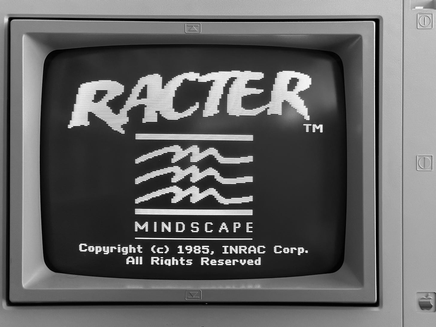 Photo of a computer monitor displaying the title screen for a program named "Racter" with a 1985 copyright date.