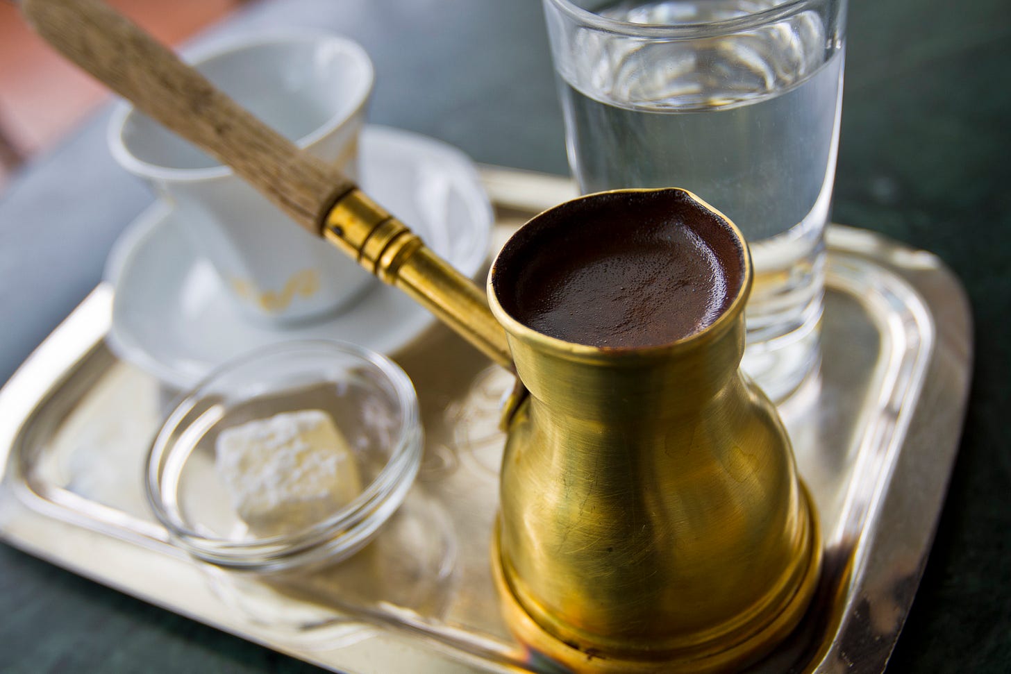 Turkish coffee in a brass ibrik on a tray with Turkish Delight