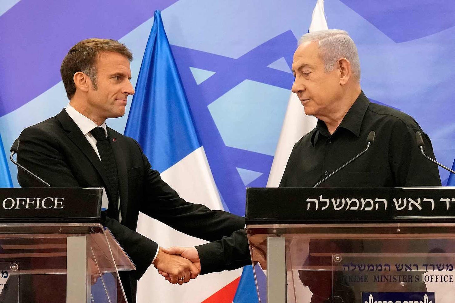 Israeli Prime Minister Benjamin Netanyahu shakes hands with French President Emmanuel Macron.