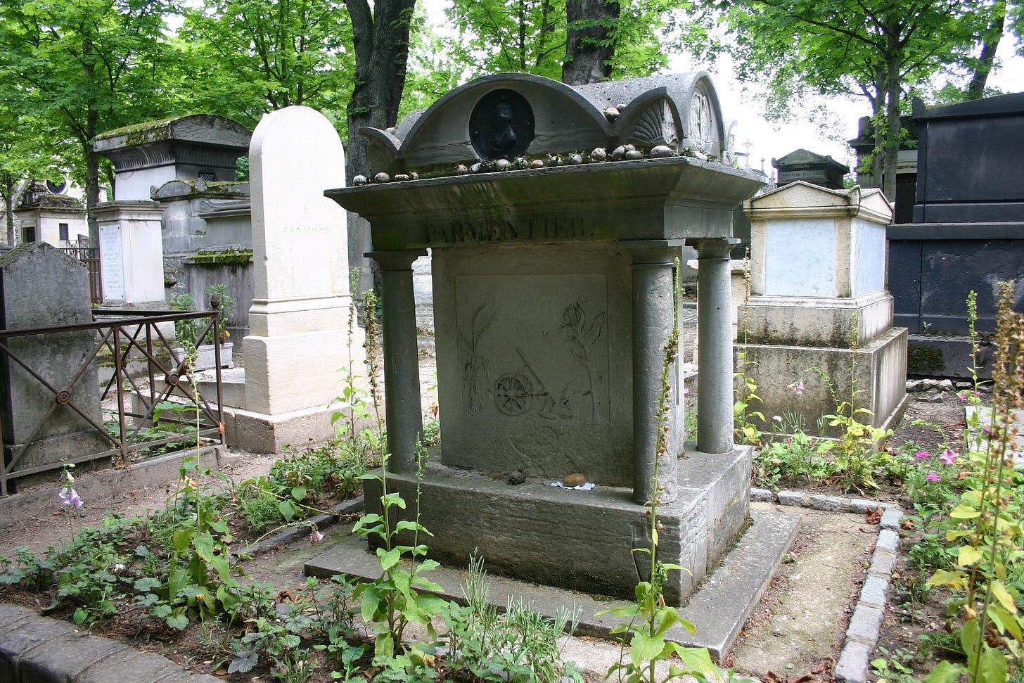 Parmentier's tomb, surrounded by what I'm frankly taking on trust are potato plants. Also, there are potatoes on top of the tomb.