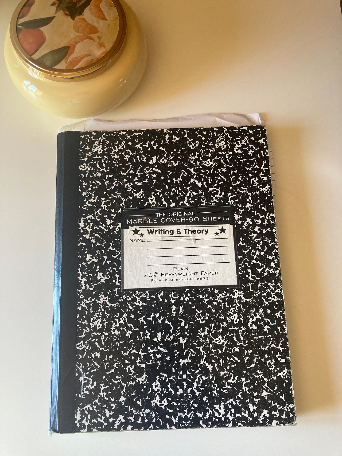 A composition notebook with a label that says "Writing and theory"