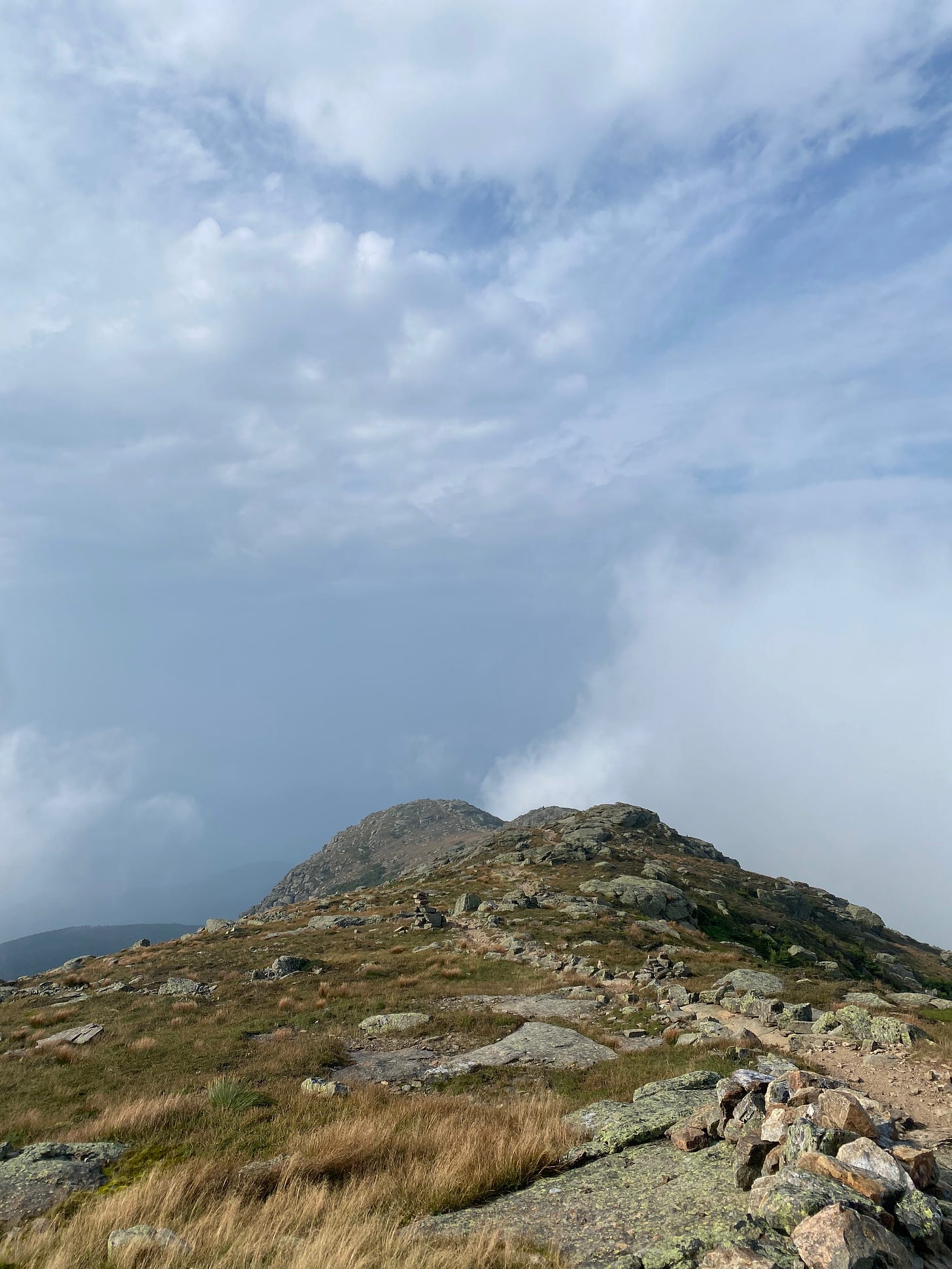 A view of the shoulder of Mt. Lafayette, a rocky ridge, under a cloudy sky.