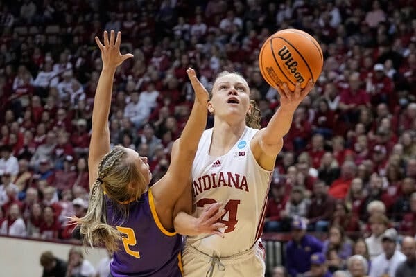 Indiana’s Grace Berger, in a white No. 34 jersey, shoots with her left hand past the outstretched arms of Tennessee Tech’s Jordan Brock.