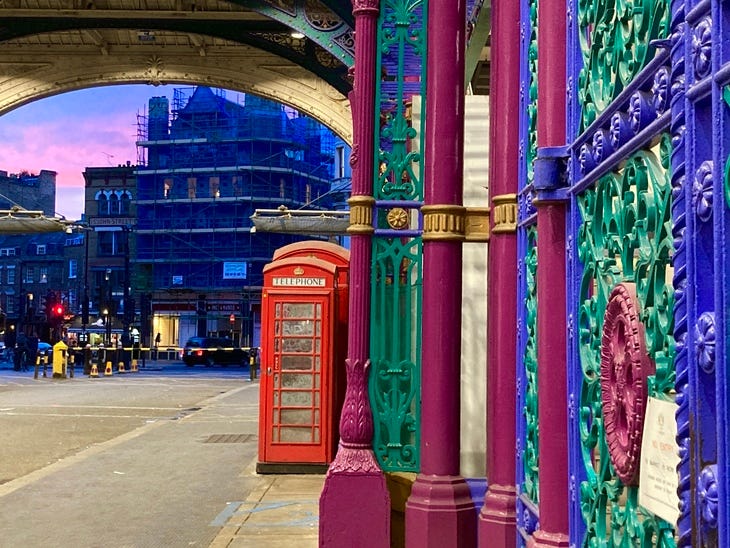 A colourful Smithfield Market with red phone boxes inside