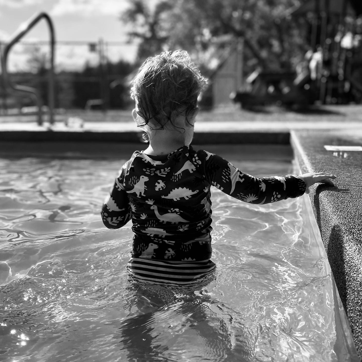 Child in small pool with hand on wall