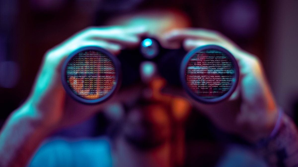 A pair of binoculars covered with code, indicating a cybersecurity breach
