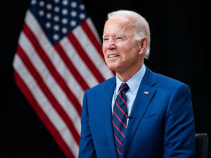 A picture of President Joe Biden in front of the United States flag.
