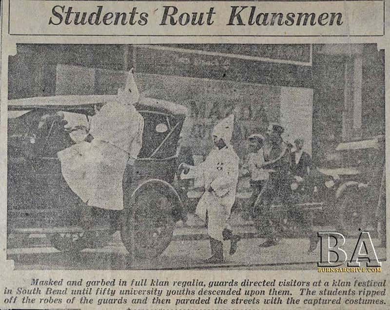 A newspaper clipping, with a photo of students wearing Klan robes, captioned: 'Masked and garbed in full klan regalia, guards directed visitors at a klan festival in South Bend until fifty university youths descended upon them. The students ripped off the robes of the guards and then paraded the streets with the captured costumes. A newspaper clipping, with a photo of students wearing Klan robes, captioned: 'Masked and garbed in full klan regalia, guards directed visitors at a klan festival in South Bend until fifty university youths descended upon them. The students ripped off the robes of the guards and then paraded the streets with the captured costumes.