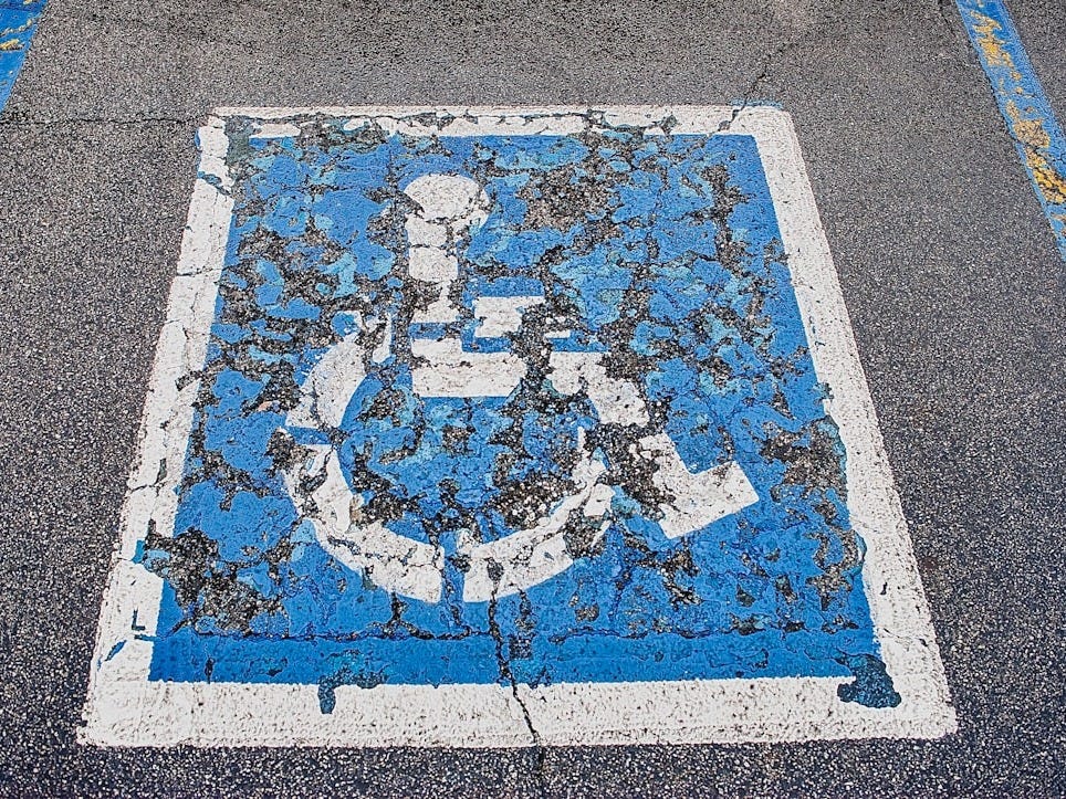 a blue and white sign on the side of a road