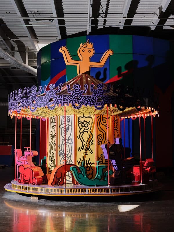 A rainbow-colored carousel featuring Keith Haring’s signature figures.