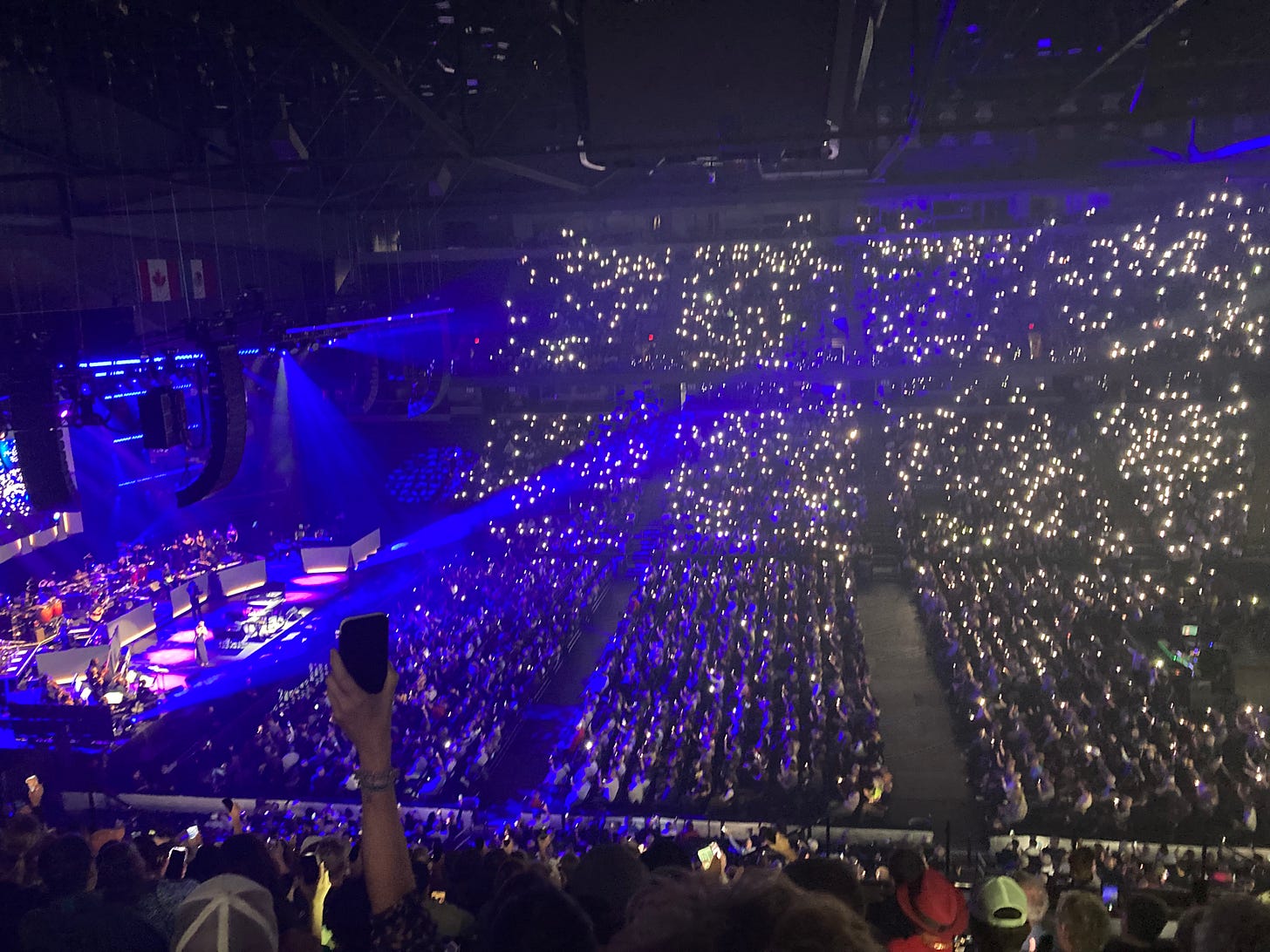 the arena filled with people holding up their cell phone lights