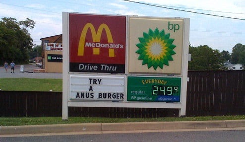 Photo of a McDonald's sign board altered to read 'TRY A ANUS BURGER,' circa 2009