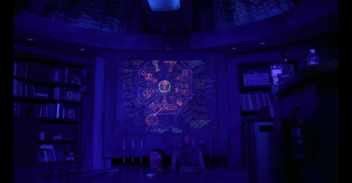 John Locke looks up at the luminescent map painted onto the blast door beneath which he is pinned.