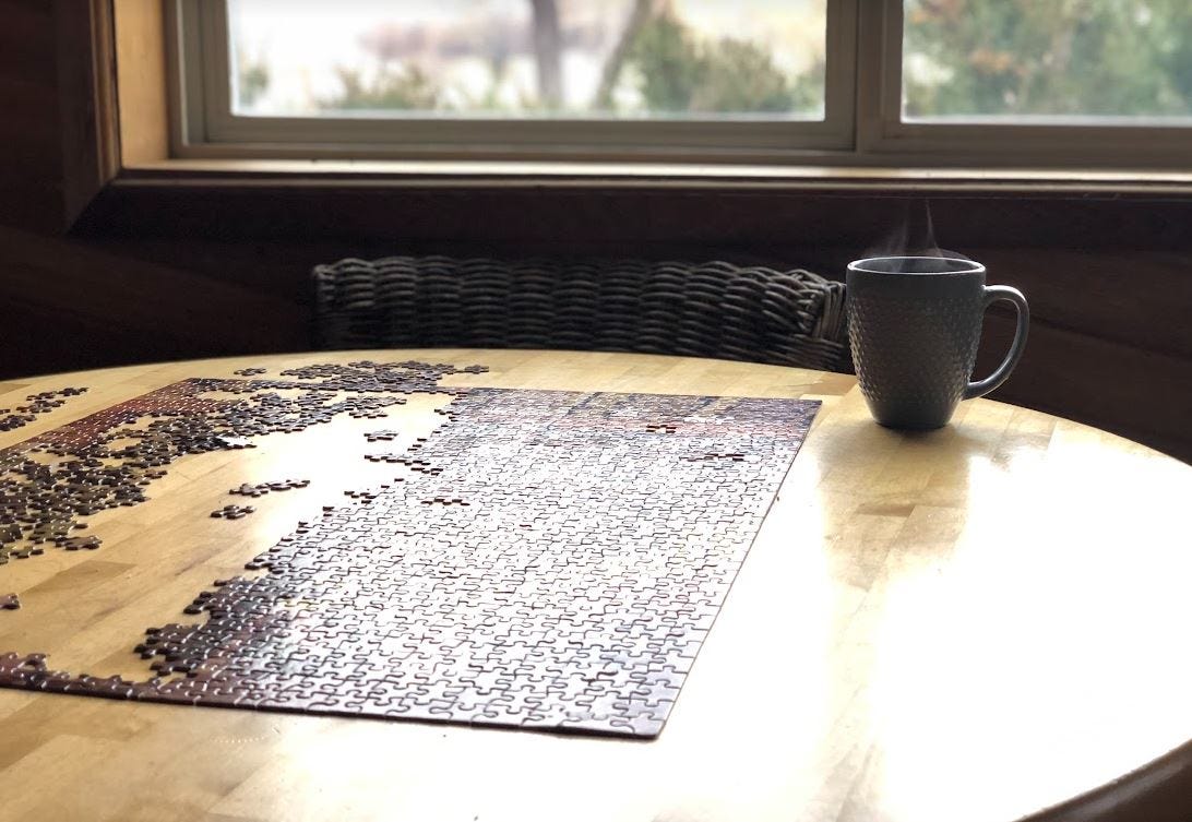 Cup of tea and puzzle on wooden table