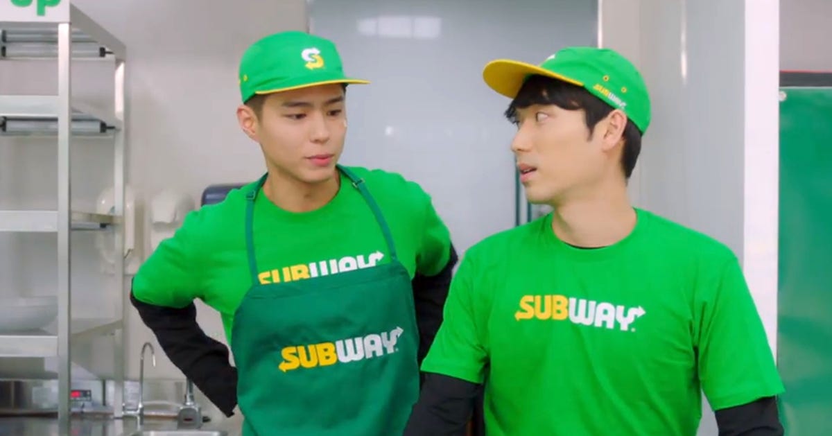 Two kdrama actors dressed as Subway sandwich shop employees