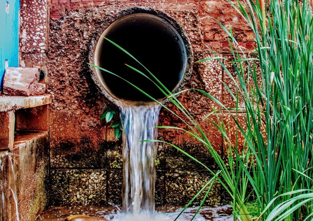 a pipe running out of a pipe on a brick wall