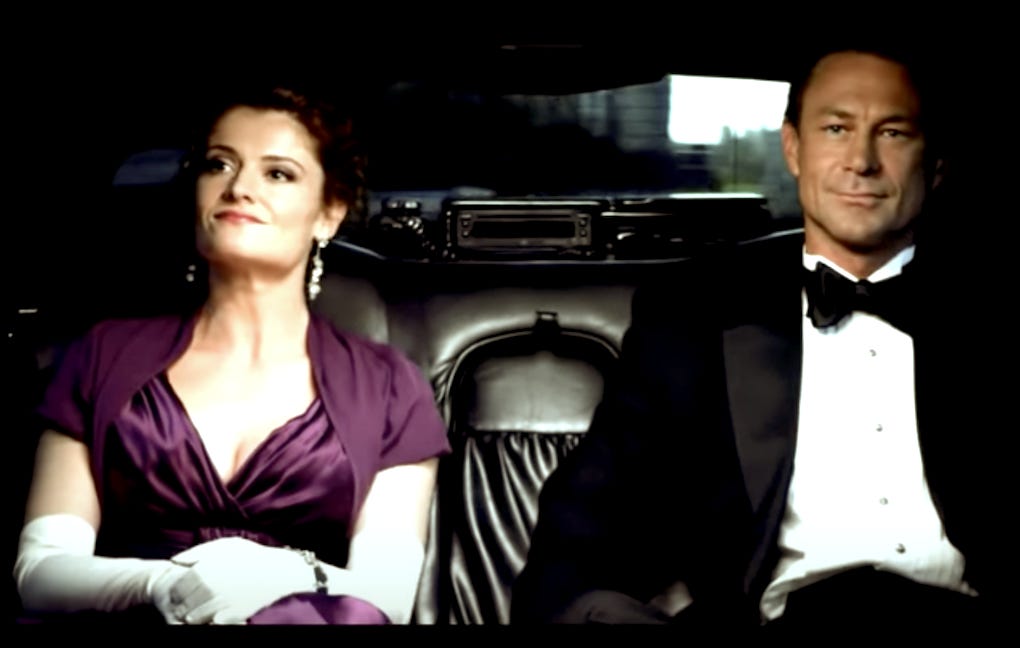 Image extraite du film Atlas Shrugged I (2011): une femme (Dagny Taggart/Taylor Schilling) et un homme (Henry Rearden/Grant Bowler), en voiture.