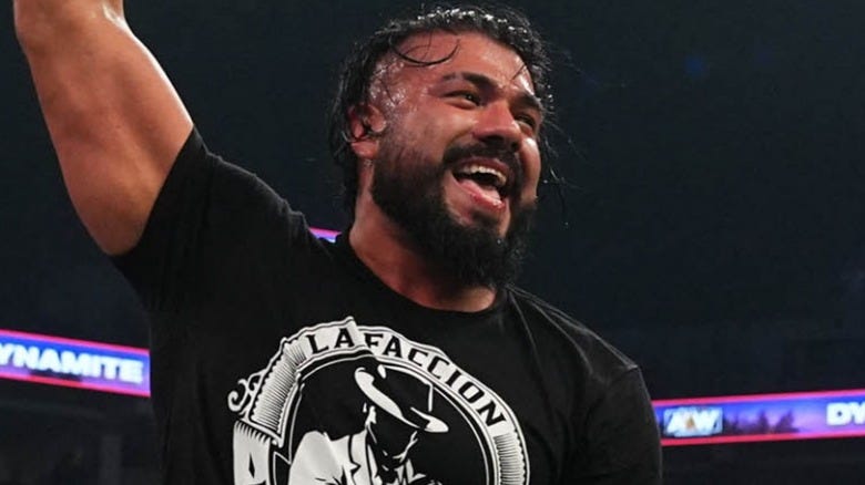 Andrade El Idolo laughing with his arm raised